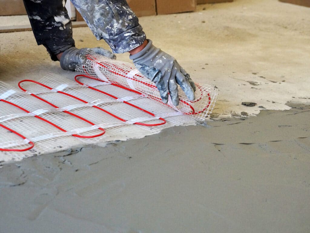 laying an electric underfloor heating under a cement screed close-up