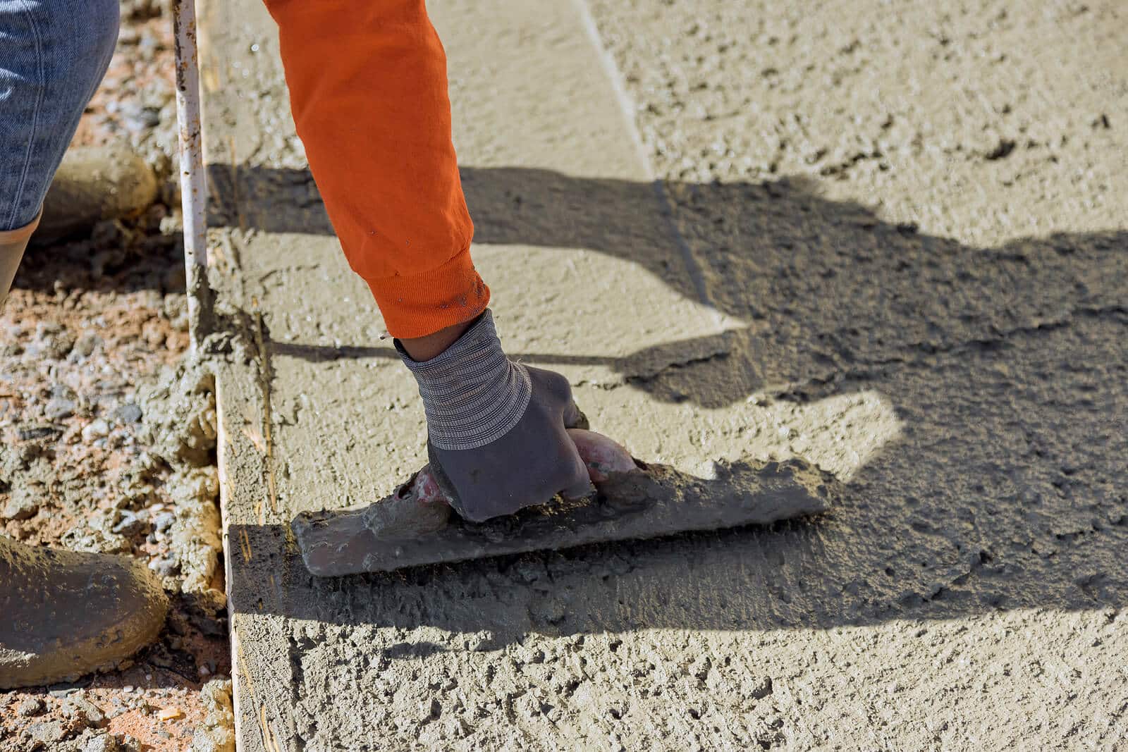 worker smoothing out freshly poured concrete
