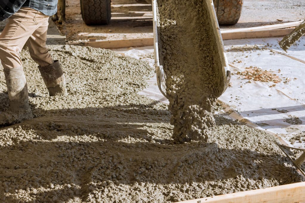mixed concrete being poured onto the ground